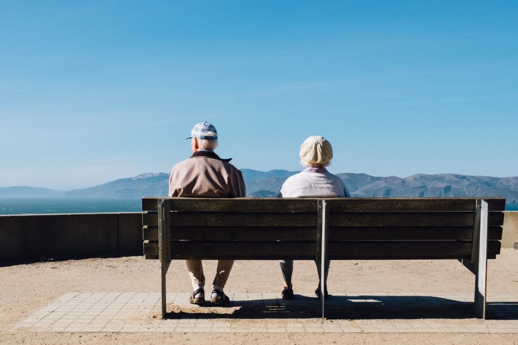 Two Older People on Bench viewing mountains